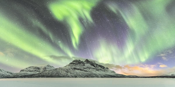 Northern lights in the sky above Skoddebergvatnet lake. Grovfjord, Troms county, Northern Norway, Norway.