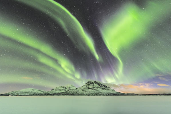 Northern lights in the sky above Skoddebergvatnet lake. Grovfjord, Troms county, Northern Norway, Norway.