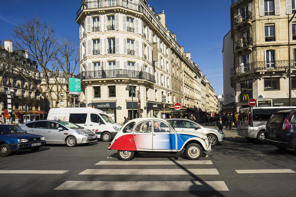 A vintage Citroen car painted in the colours of the France flag gets stuck in the city traffic, Paris, France