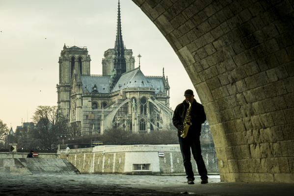 Musician in Paris under a bridge along the river Seine, Paris, France