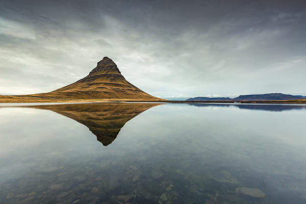 Kirkjufell Mountain reflects itself on the Atlantic waters in Snaefellsnes peninsula, Iceland, Europe.
