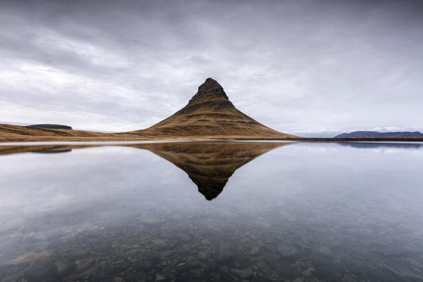Kirkjufell Mountain reflects itself on the Atlantic waters in Snaefellsnes peninsula, Western Iceland, Europe.