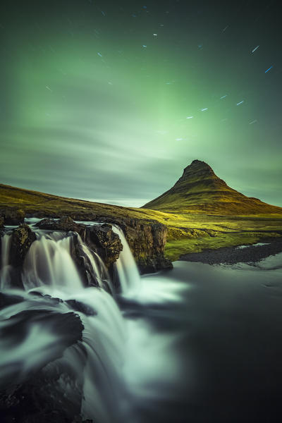 Long exposure landscape with waterfalls and aurora borealis above Kirkjufell Mountain, Snaefellsnes peninsula, Western Iceland, Europe.