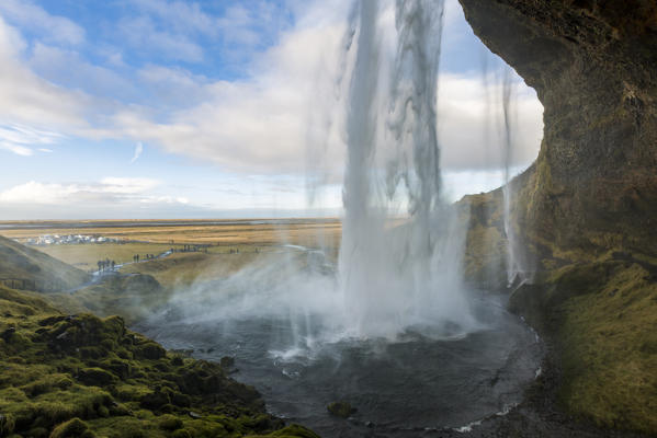 Tourists staring at Seljalandsfoss waterfall,  Porsmerkurvegur, Sudurland, Iceland, Europe