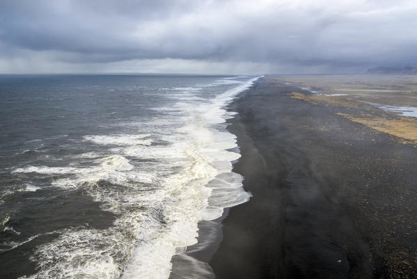 Aerial view of the long black sand beach of Reynisfjara, Vik, Sudurland, Iceland, Europe