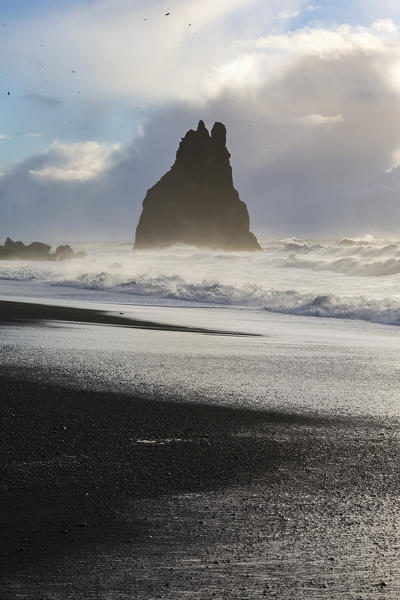 Rock emerging from the ocean at the beach of Reynisfjara, Vik, Sudurland, Iceland, Europe