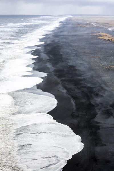 Aerial view of the long black sand beach of Reynisfjara, Vik, Sudurland, Iceland, Europe