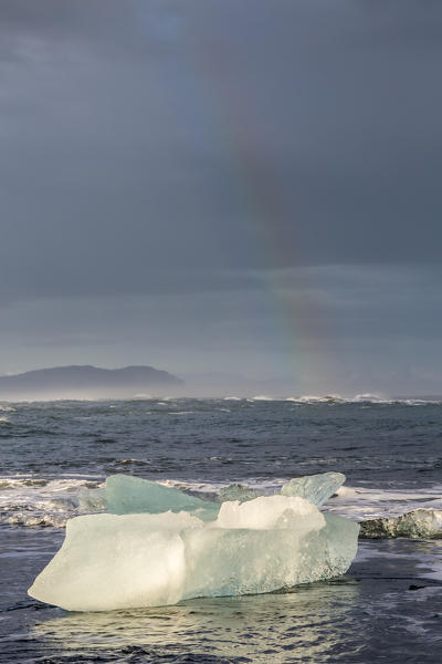 Ice blocks and rainbow. Jokulsarlon Glacier Lagoon, Eastern Iceland, Europe