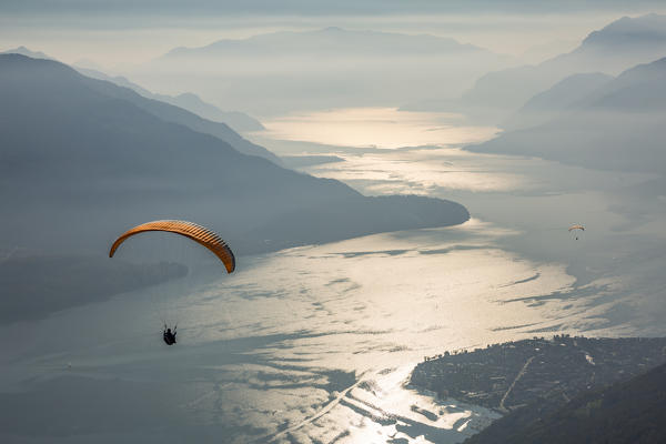 Paragliding over Lake Como and the surroundings mountains. Alto Lario, Como, Lombardy, Italy, Europe.