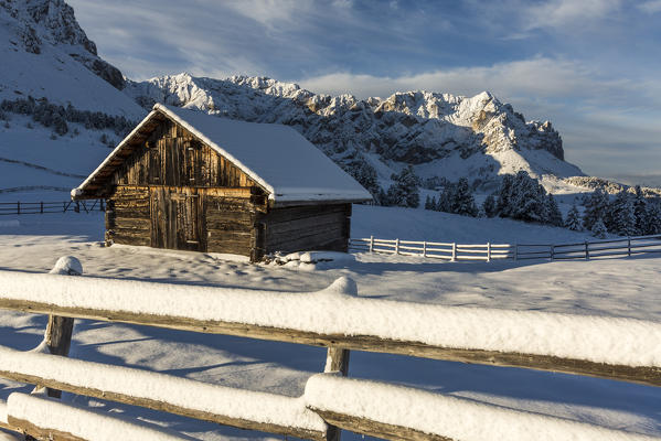Wooden lodge and fence covered in snow. Passo delle Erbe, Bolzano, Trentino Alto Adige - Sudtirol, Italy, Europe.