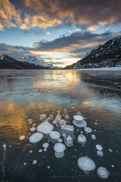 Frozen gas bubbles trapped in the ice at sunset. Silvaplana Lake, Silvaplana, Engadin, Graubunden, Switzerland, Europe.