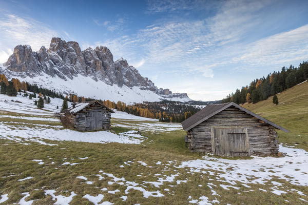 Two wooden lodges and Odle Dolomites. Malga Gampen, Funes, Bolzano, Trentino Alto Adige - Sudtirol, Italy, Europe.