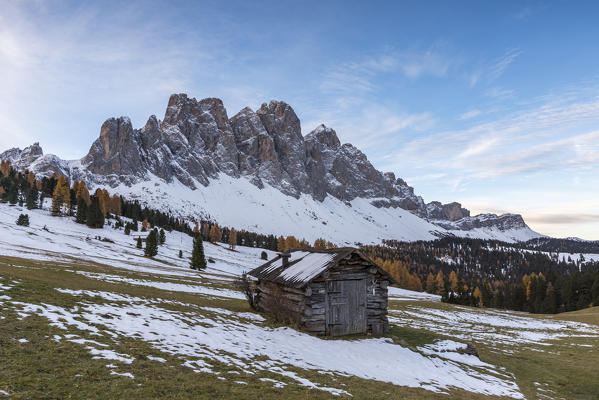 Wooden lodge and Odle Dolomites. Malga Gampen, Funes, Bolzano, Trentino Alto Adige - Sudtirol, Italy, Europe.
