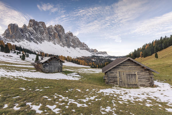 Two wooden lodges and Odle Dolomites. Malga Gampen, Funes, Bolzano, Trentino Alto Adige - Sudtirol, Italy, Europe.