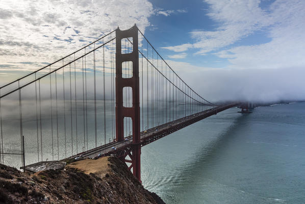 Golden Gate Bridge with morning fog shot at sunrise from Slackers Hill. San Francisco, Marin County, California, USA.
