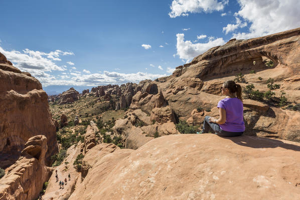 Girl overlooking the landscape on Devil's Garden trailhead. Arches National Park, Moab, Grand County, Utah, USA.