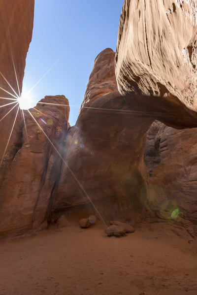 The sun shines over Sand Dune Arch. Arches National Park, Moab, Grand County, Utah, USA.