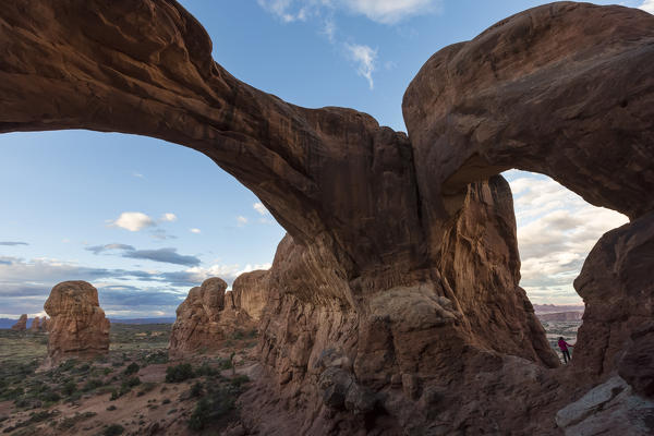 Person under Double Arch. Arches National Park, Moab, Grand County, Utah, USA.