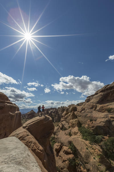 Couple of hikers. Devil's Garden trailhead, Arches National Park, Moab, Grand County, Utah, USA.