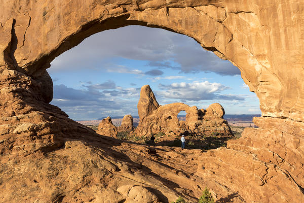 Man overlooking Turret Arch from North Window. Arches National Park, Moab, Grand County, Utah, USA.