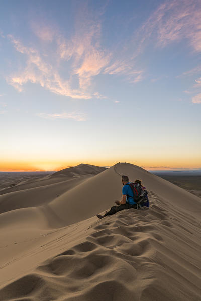 Man watching the sunset in Gobi Gurvan Saikhan National Park. Sevrei district, South Gobi province, Mongolia.
