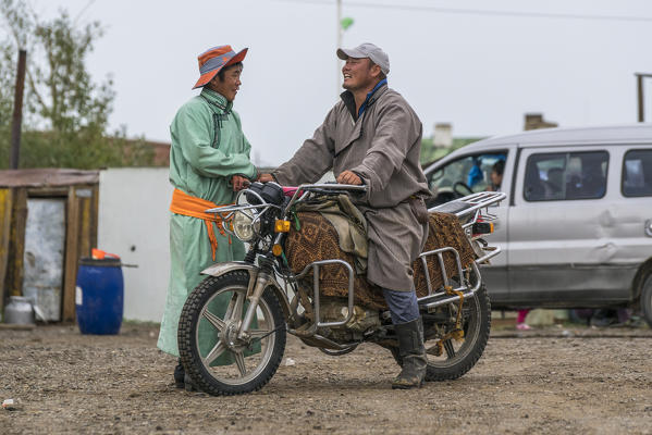 Man on a motorbike chatting with another man. Huzirt, South Hangay province, Mongolia.