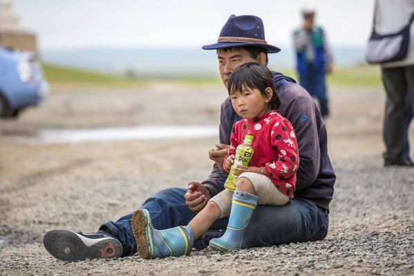 Father and daughter sitting on the ground. Harhorin, South Hangay province, Mongolia.