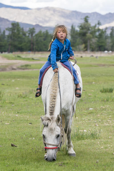 Mongolian nomadic little girl riding a horse. Hovsgol province, Mongolia.