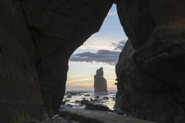 Rock cave with low tide at the Three Sisters. Tongaporutu, New Plymouth district. Taranaki region, North Island, New Zealand.