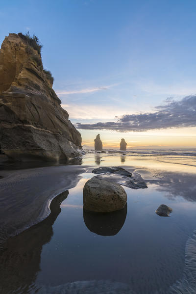 Reflection of the Three Sisters with low tide, at sunset. Tongaporutu, New Plymouth district. Taranaki region, North Island, New Zealand.