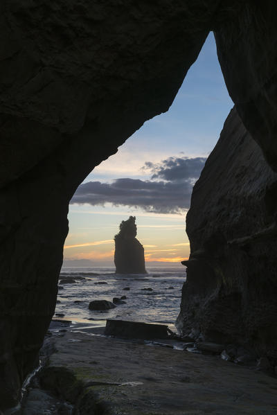 Rock cave with low tide at the Three Sisters. Tongaporutu, New Plymouth district. Taranaki region, North Island, New Zealand.