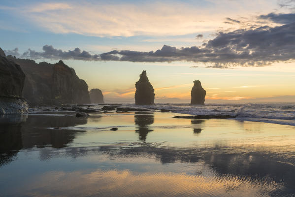 Reflection of the Three Sisters with low tide, at sunset. Tongaporutu, New Plymouth district. Taranaki region, North Island, New Zealand.