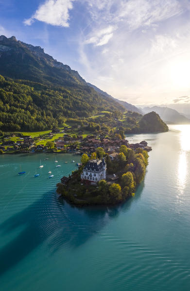 Aerial view of the village of Iseltwald and it's peninsula with the old Castle during an autumnal sunset on Lake Brienz. Iseltwald, Lake Brienz, Bernese Oberland, Interlaken-Oberhasli district, Canton of Bern, Switzerland.