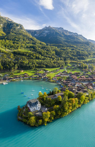Aerial view of the village of Iseltwald and it's peninsula with the old Castle during an autumnal sunset on Lake Brienz. Iseltwald, Lake Brienz, Bernese Oberland, Interlaken-Oberhasli district, Canton of Bern, Switzerland.
