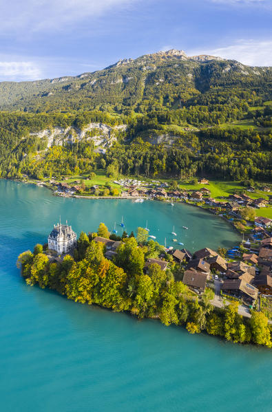 Aerial view of the village of Iseltwald and it's peninsula with the old Castle during an autumnal sunset on Lake Brienz. Iseltwald, Lake Brienz, Bernese Oberland, Interlaken-Oberhasli district, Canton of Bern, Switzerland.