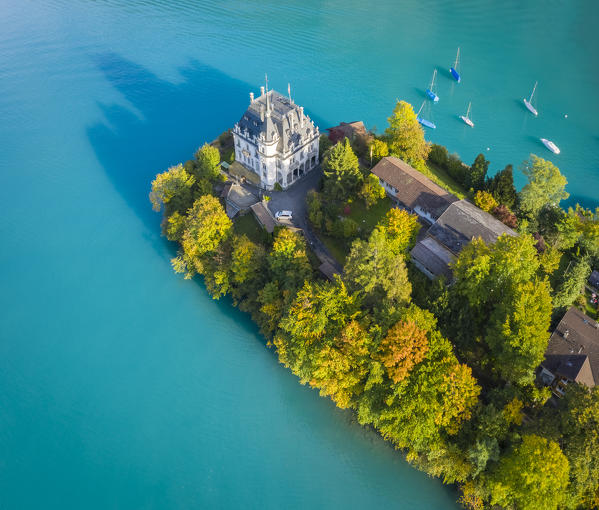 Aerial view of the village of Iseltwald and it's peninsula with the old Castle during an autumnal sunset on Lake Brienz. Iseltwald, Lake Brienz, Bernese Oberland, Interlaken-Oberhasli district, Canton of Bern, Switzerland.