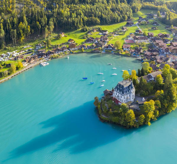 Aerial view of the village of Iseltwald and it's peninsula with the old Castle during an autumnal sunset on Lake Brienz. Iseltwald, Lake Brienz, Bernese Oberland, Interlaken-Oberhasli district, Canton of Bern, Switzerland.