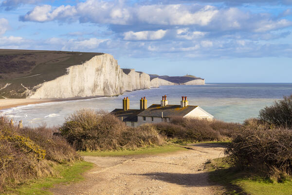 View of the Seven Sisters cliffs and the coastguard cottages, from Seaford Head across the River Cuckmere.  Seaford, Sussex, England, United Kingdom.