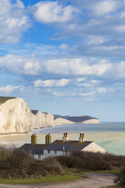 View of the Seven Sisters cliffs and the coastguard cottages, from Seaford Head across the River Cuckmere.  Seaford, Sussex, England, United Kingdom.