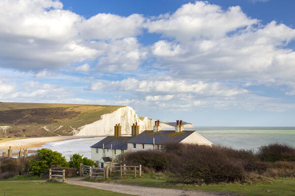 View of the Seven Sisters cliffs and the coastguard cottages, from Seaford Head across the River Cuckmere.  Seaford, Sussex, England, United Kingdom.