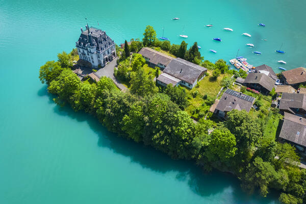 Aerial view of the village of Iseltwald and it's peninsula with the old Castle on Lake Brienz. Iseltwald, Lake Brienz, Bernese Oberland, Interlaken-Oberhasli district, Canton of Bern, Switzerland.