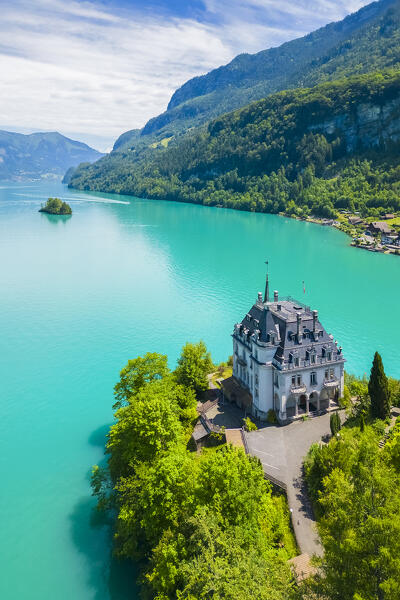 Aerial view of the village of Iseltwald and it's peninsula with the old Castle on Lake Brienz. Iseltwald, Lake Brienz, Bernese Oberland, Interlaken-Oberhasli district, Canton of Bern, Switzerland.
