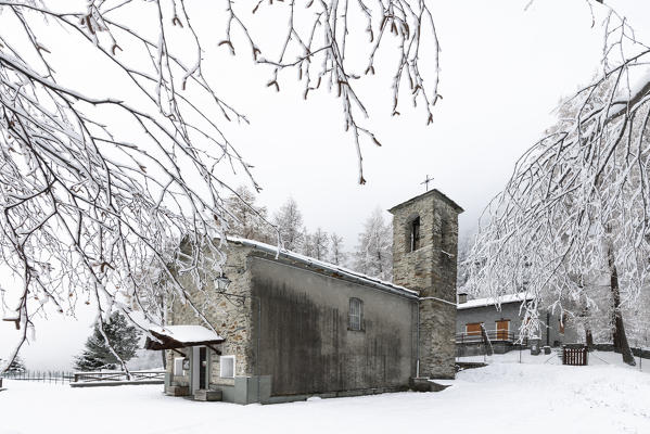 Medieval church in the snowy landscape, San Giuseppe, Chiesa in Valmalenco, Malenco Valley, Sondrio province, Valtellina, Lombardy, Italy