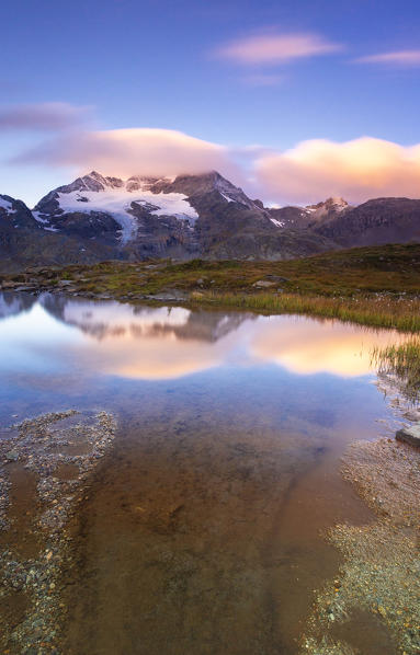 Sunrise on Piz Cambrena mirrored in the alpine lake, Val Dal Bugliet, Bernina Pass, canton of Graubunden, Engadine, Switzerland