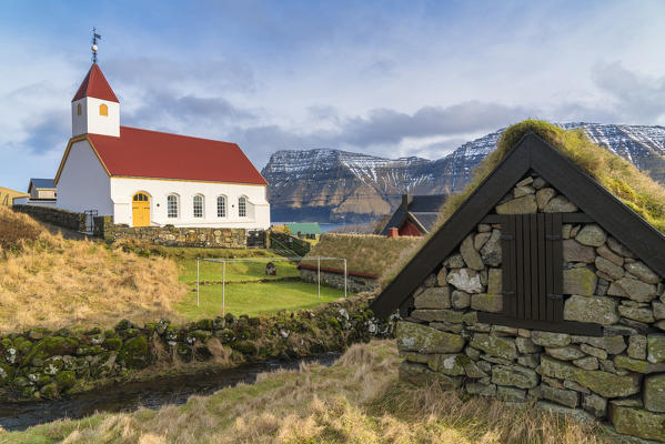 Stone hut with grass roof next to church of Mikladalur, Kalsoy island, Faroe Islands, Denmark
