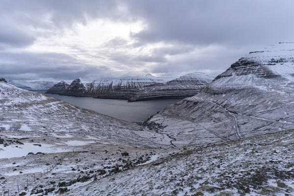 Clouds on snowy peaks and Funningur village, Eysturoy island, Faroe Islands, Denmark