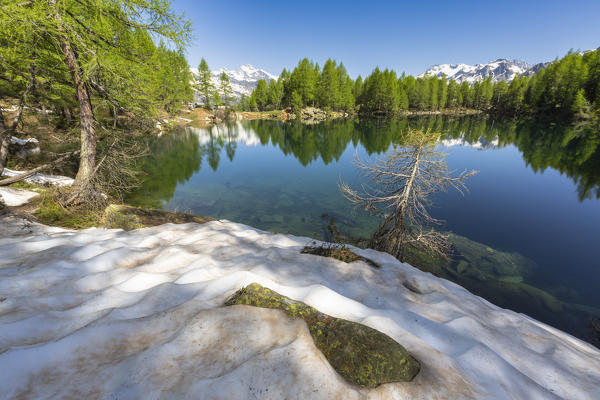 Snow on the shore of Lago Azzurro during spring, Motta, Madesimo, Valle Spluga, Valtellina, Sondrio province, Lombardy, Italy