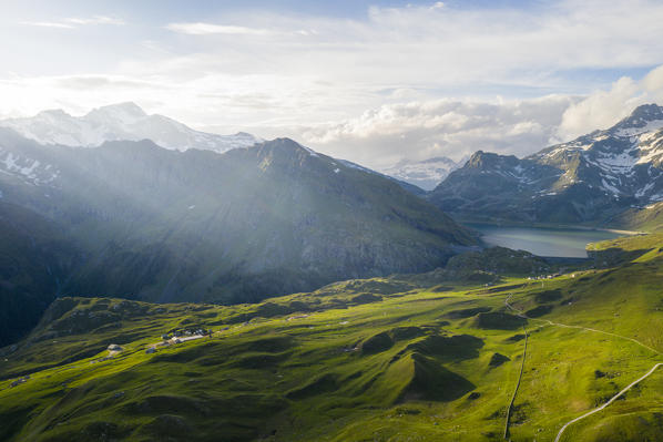 Aerial view of sun rays over Andossi towards lake Montespluga and Pizzo Tambò, Madesimo, Valchiavenna, Valtellina, Lombardy, Italy