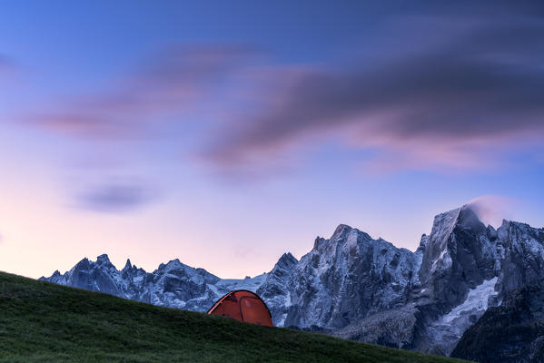 Tent in front of Piz Badile, Piz Cengalo and Sciore group lit by dawn, Tombal, Soglio, Val Bregaglia, canton of Graubunden, Switzerland
