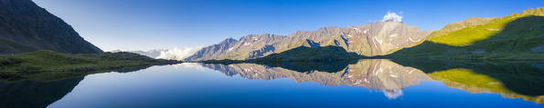 Aerial panoramic of Cima di Pietrarossa reflected in Lago Nero at sunrise, Gavia Pass, Valfurva, Valtellina, Lombardy, Italy